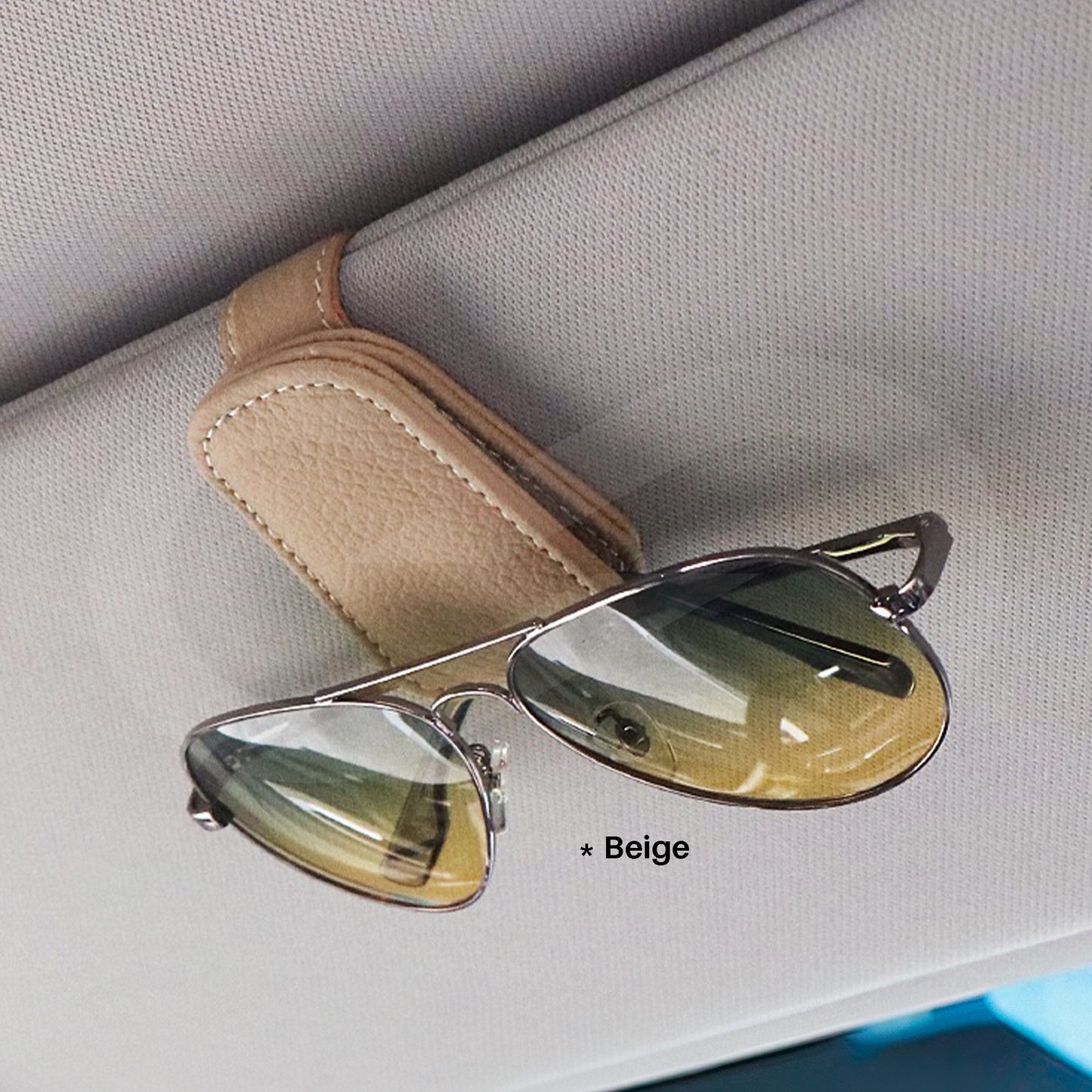 Beige sunglasses clip on a car sun visor.