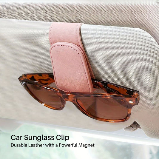 Car sunglass clip with pink leather holder and sunglasses on a car seat.